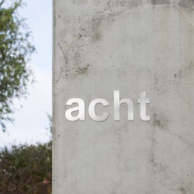 A Serafini Stainless Steel Lower Case Letters wall with the word acht written on it.