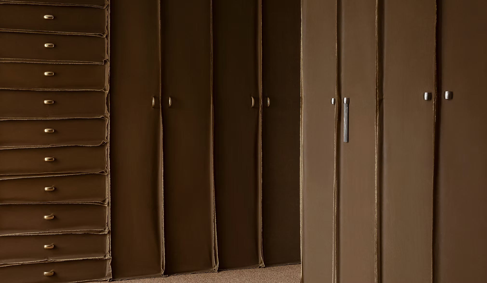 Jewel like cabinet hardware on dark brown cabinets by Swedish design brand Spaces Within.