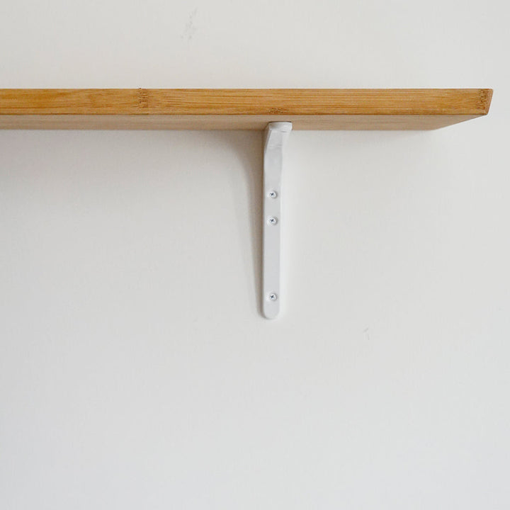 A Sugatsune shelf bracket with a white object on it.