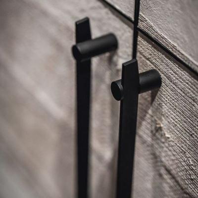 A close up of two black Formani TENSE BB25 160/320 Cabinet Handles on a cabinet.