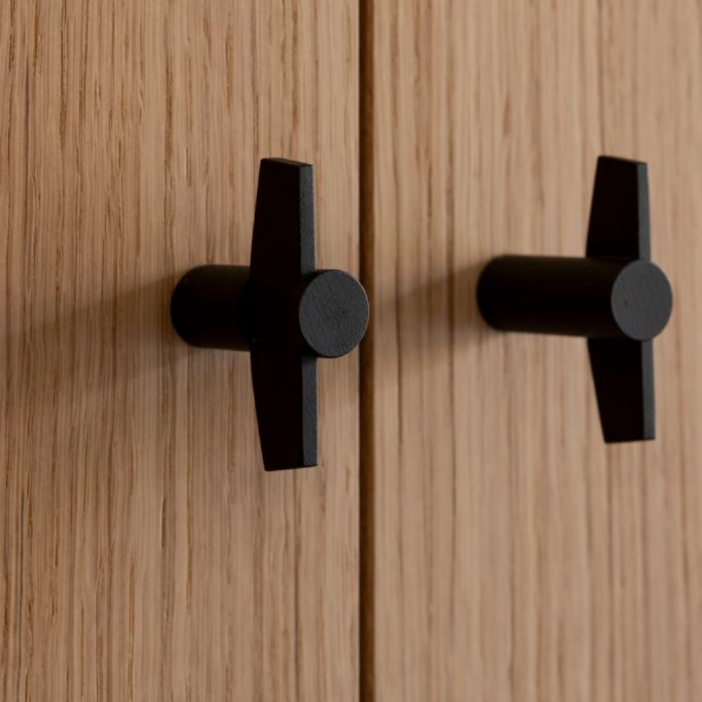 A close up of a TENSE BB25 M Cabinet Knob by Formani on a wooden door.