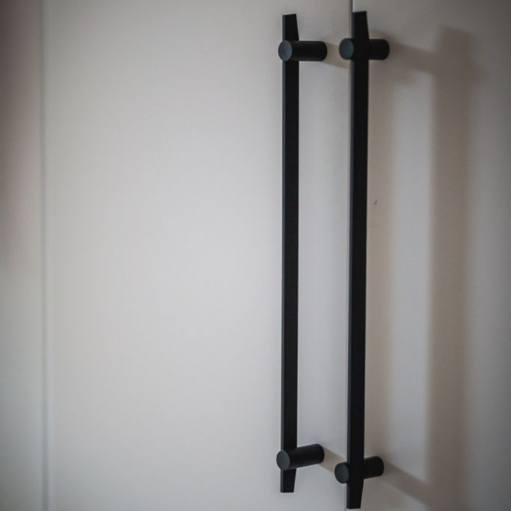 A pair of Formani TENSE BB500 Pull Handles in black on a white wall.
