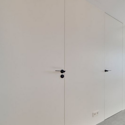 A white room with two Formani TENSE BBWC53 Privacy Set black handles on the doors.