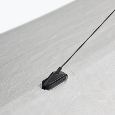 A black New Works Tense Pendant Lamp with a cord attached to it.