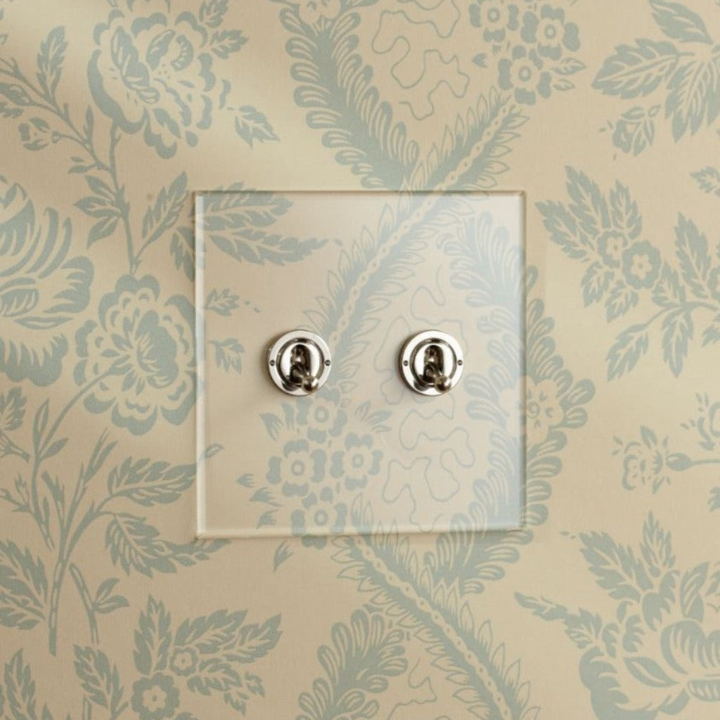 Forbes & Lomax invisible plate with two toggle switches on wallpaper.