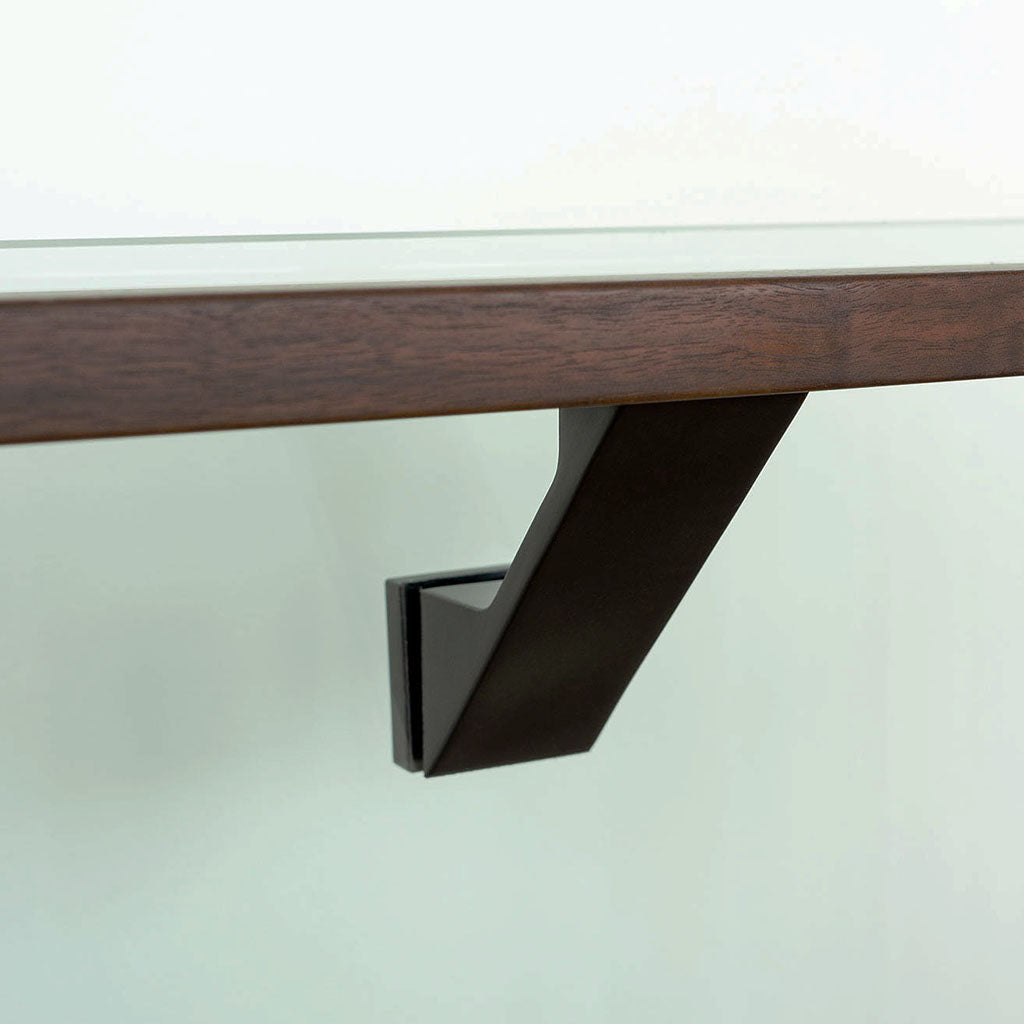A close up of a wooden shelf with a Componance VS Glass Mounted Bracket.