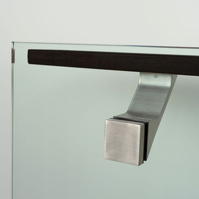 A close up of a Componance VS Glass Mounted Bracket on a glass door handle.