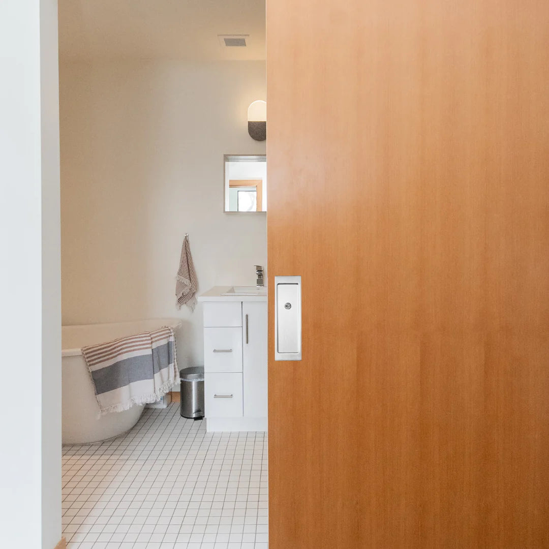 A bathroom with an AHI Explore Pocket Door Set Privacy for the toilet and sink.