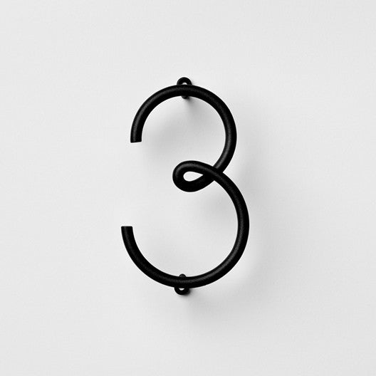 A NakNak black metal Wire Number Neutral eight on a white background.