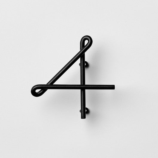 A NakNak Wire Number Neutral clock on a white wall with a number four on it.