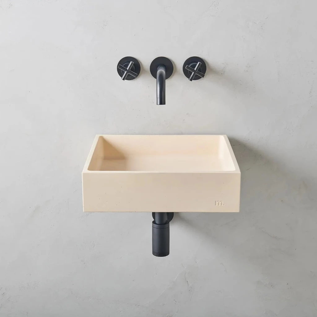 A Yarra Basin LG Affix from mudd. concrete with a black faucet and two black handles.