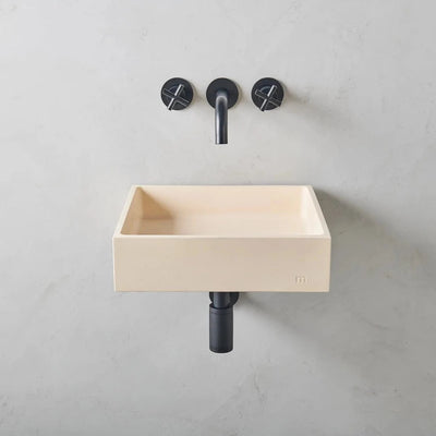 A Yarra Basin LG Affix from mudd. concrete with a black faucet and two black handles.