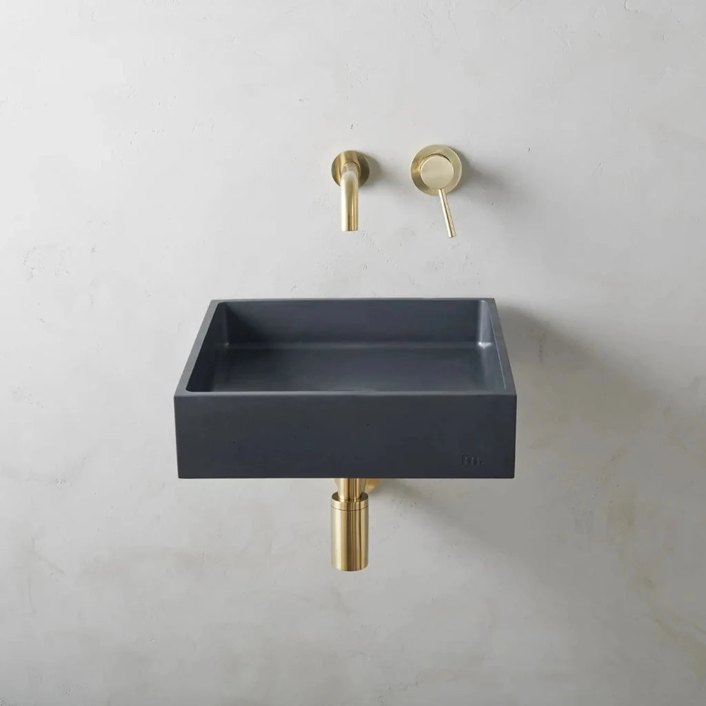 A mudd. concrete Yarra Basin LG Affix bathroom sink with a gold faucet and soap dispenser.