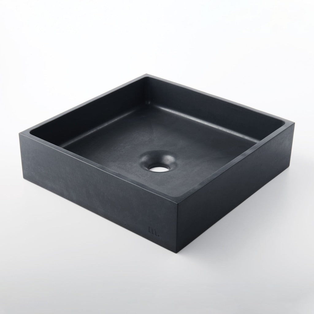 A black Yarra Basin LG sink with a hole in the middle by mudd. concrete.