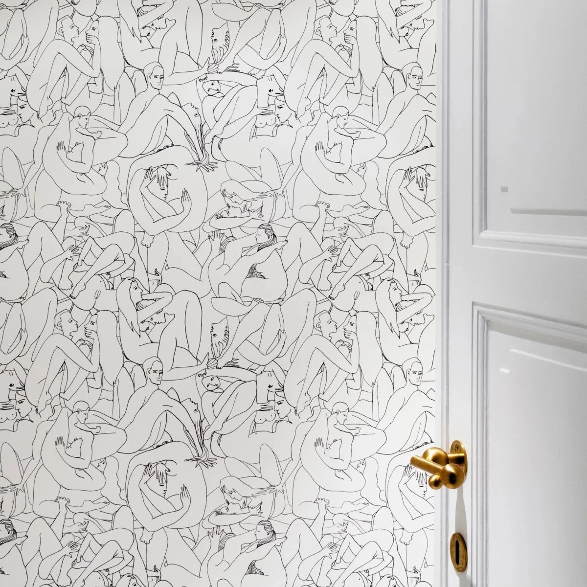 Vervloet Bubbles door lever on a white door beside patterned wallpaper.