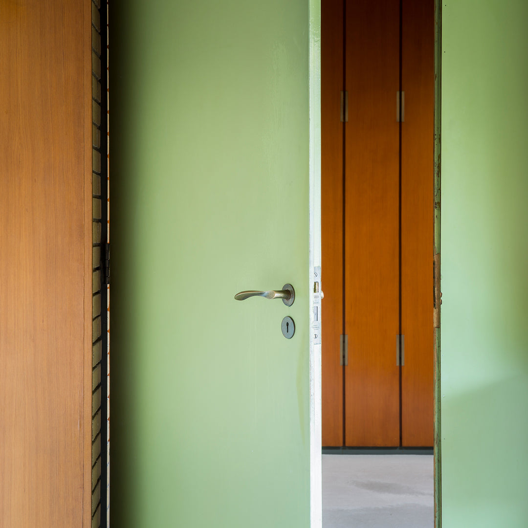 Modernist Arne Jacobsen door lever set on a mint green door