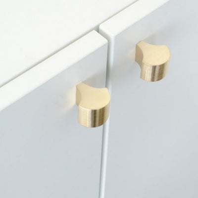 Brushed brass knobs mounted on cabinet