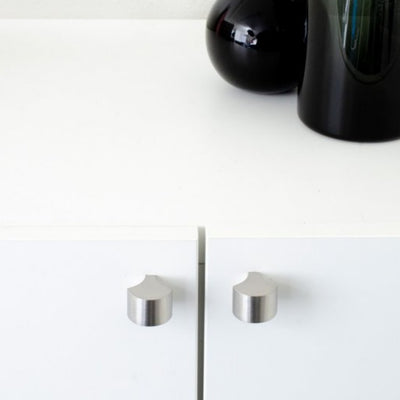Brushed stainless steel knobs mounted on cabinet