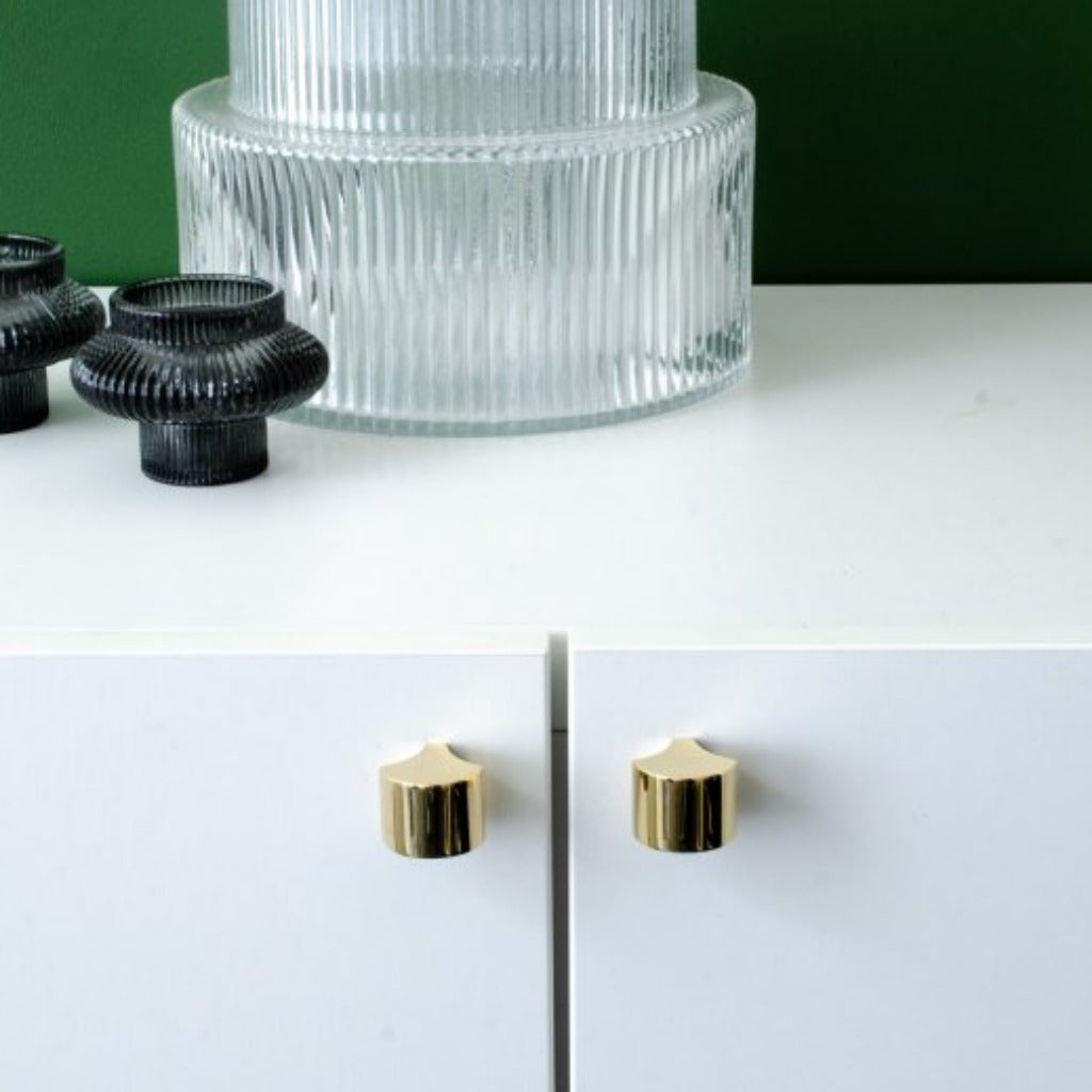 Polished brass knobs mounted on cabinet