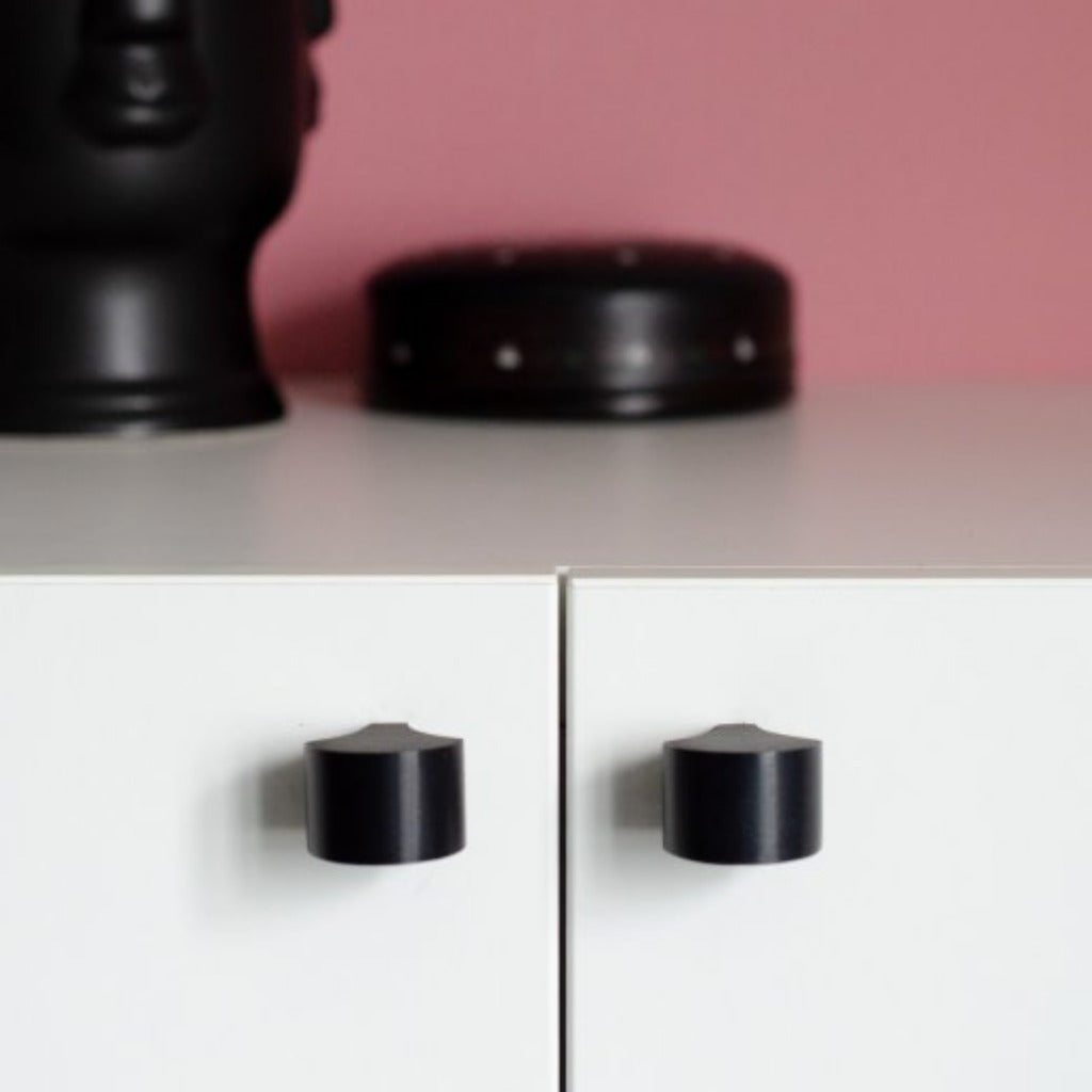 Matte black knobs mounted on cabinet