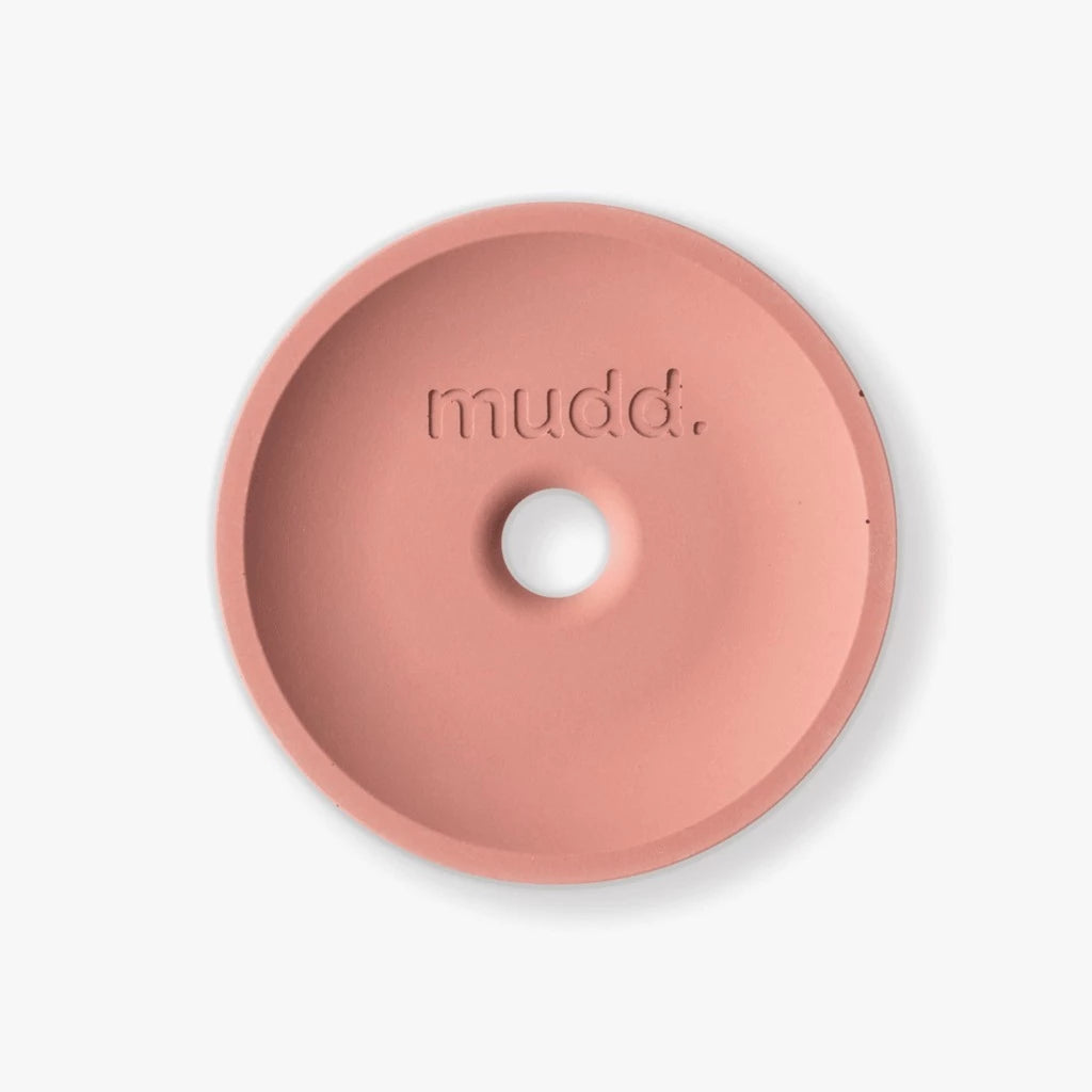 A pink bowl with the word mudd. concrete on it.