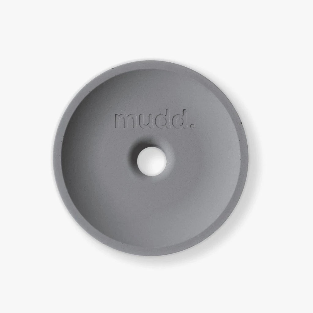 A round object with the word Mudd. Concrete on it.