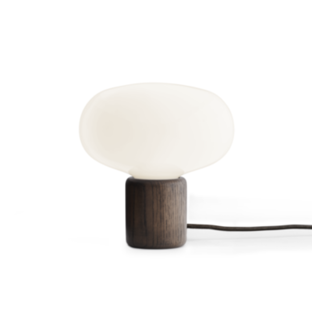 A table lamp with a dark oak base and a rounded opal glass top