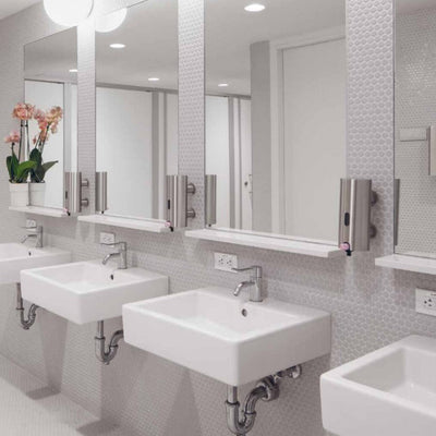 A row of Knud Soap Dispensers and mirrors in a bathroom by d line.