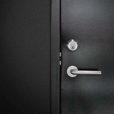 Knud L Lever in satin stainless steel installed on a black industrial door with a Knud keyed lock.